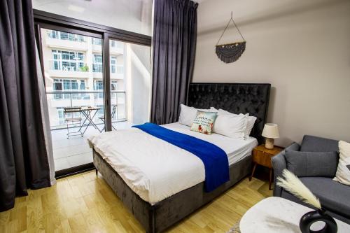 sypialnia z łóżkiem, kanapą i oknem w obiekcie Furnished Studio In Binghatti Apartments, Dso w Dubaju