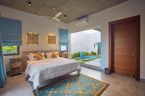 a bedroom with a bed and a sliding glass door at Manna Villa in Mahabalipuram