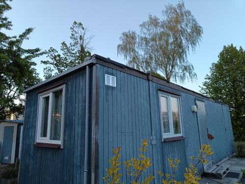 a blue tiny house with two windows at Templis in Jelgava