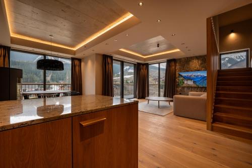 a kitchen and living room with a couch and a table at Swissôtel Damian Jasna in Demanovska Dolina