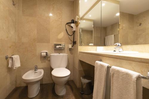 a bathroom with a toilet and a sink at Best Western Premier CMC Girona in Girona
