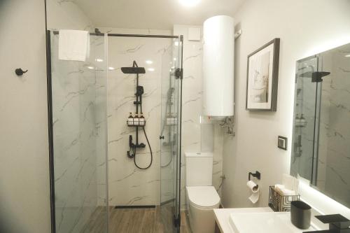 een badkamer met een douche, een toilet en een wastafel bij Golden Sands - Two Bedroom apartment on the beach in Goudstrand