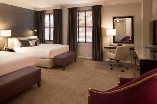 a hotel room with two beds and a desk at Hotel De Anza in San Jose