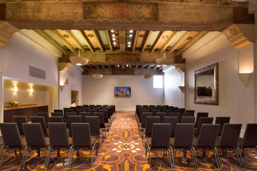 a room with rows of chairs and a stage at Hotel De Anza in San Jose