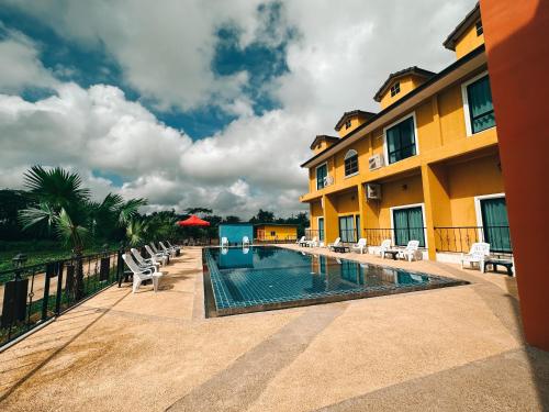 a resort swimming pool with chairs and a building at Tuscany Hotel Buriram in Buriram