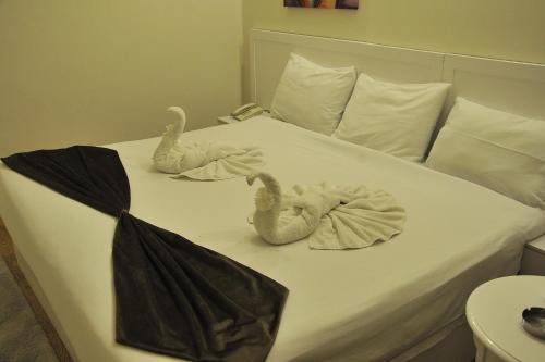 a bed with two towel animals on it at Salma Hotel Cairo in Cairo