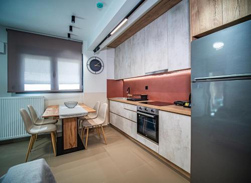 a small kitchen with a table and a refrigerator at Nestia urban apartments in Volos