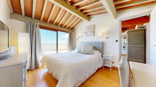 ein Schlafzimmer mit einem Bett und einem großen Fenster in der Unterkunft La Petite Auberge in Tourtour