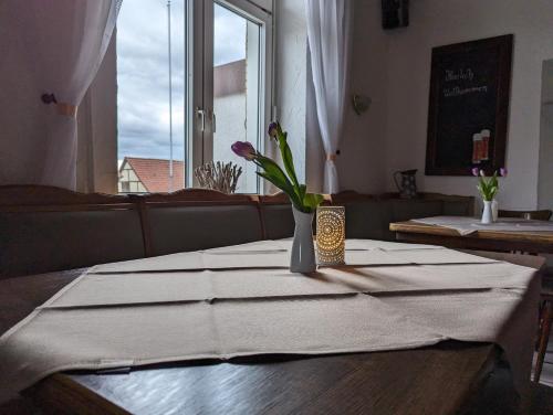 a table with a vase of flowers on a table at Sonnenhof in Katlenburg-Lindau