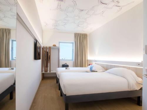 2 Betten in einem Zimmer mit weißen Wänden in der Unterkunft Ibis Abdelmoumen Casa Centre in Casablanca
