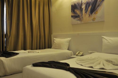 a hotel room with two beds and a window at Salma Hotel Cairo in Cairo