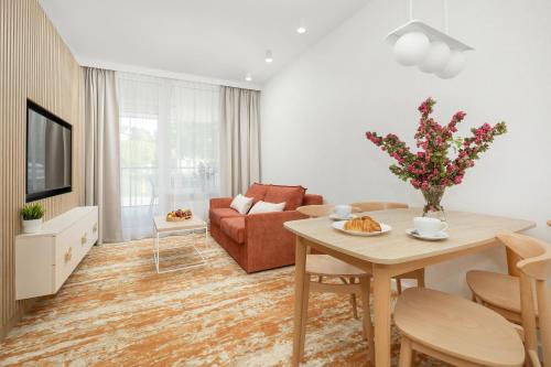 a living room with a table and a couch at Sun & Beach Apartments Bel Mare with Parking by Noclegi Renters in Międzyzdroje