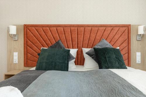 a bedroom with a large bed with two pillows at Sun & Beach Apartments Bel Mare with Parking by Noclegi Renters in Międzyzdroje