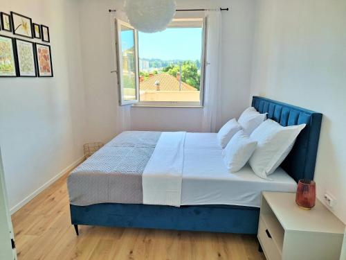 a bedroom with a blue bed with a window at Blue Promenade Apartments in Dubrovnik