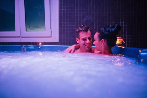Un uomo e una donna in una vasca da bagno di Hotel Terme Roma ad Abano Terme