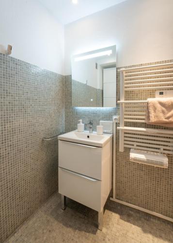 une salle de bain avec un lavabo et un miroir dans l'établissement Saint Tropez, coeur de village, appartement unique, à Saint-Tropez