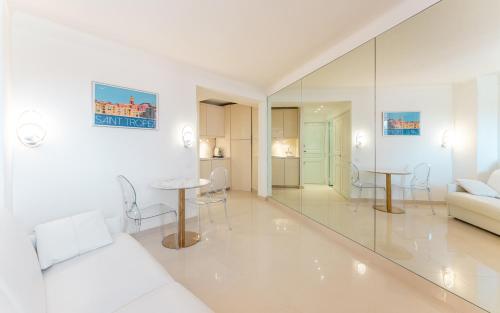 un salon blanc avec un canapé et une table dans l'établissement Saint Tropez, coeur de village, appartement unique, à Saint-Tropez