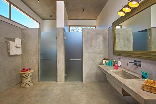 a bathroom with a shower and a sink and a mirror at Manna Villa in Mahabalipuram