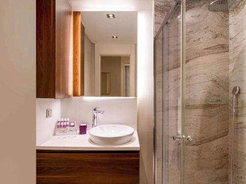 een badkamer met een wastafel en een douche bij Movenpick Living Istanbul West in Istanbul