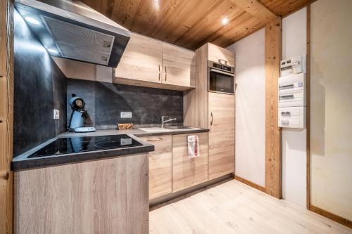 a kitchen with wooden cabinets and a sink at L' Abbaye in Abondance