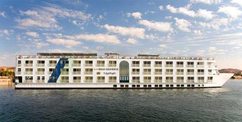 een groot hotel aan het water met een cruiseschip bij M/s Nile crown II in Nag` el-Fuqâhi