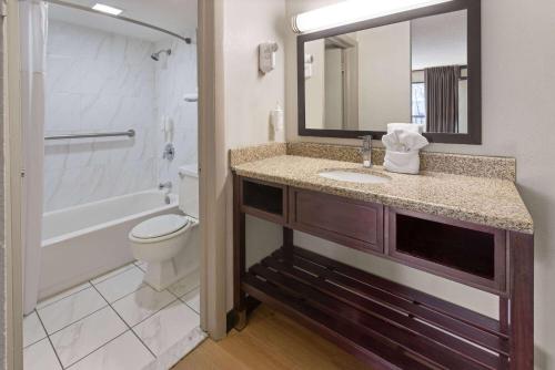 a bathroom with a sink and a toilet and a mirror at Days Inn by Wyndham Pottstown in Pottstown