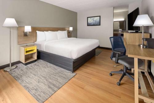 a hotel room with a bed and a desk and a desk at Days Inn by Wyndham Pottstown in Pottstown