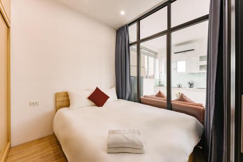 Schlafzimmer mit einem großen weißen Bett und einem Fenster in der Unterkunft Tamundi Suite Apartment- City Center- Near The Old Quarter in Hanoi