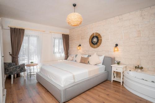a bedroom with a white bed and a bath tub at alba otel in Ildır