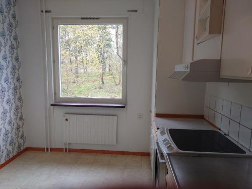 een kleine keuken met een raam en een wastafel bij Södertälje Karlhov Stay Inn in Södertälje