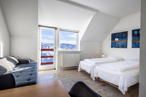 biały pokój z 2 łóżkami i kanapą w obiekcie HOTEL SØMA Ilulissat w mieście Ilulissat