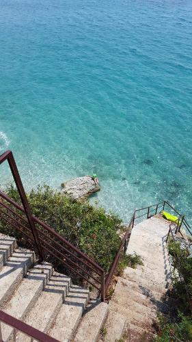 a set of stairs leading down to the water at Seaside Duplex Stone Villa in Qeparo
