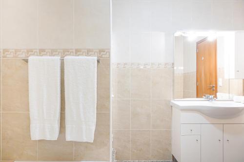 bagno con lavandino, doccia e asciugamani di Maria Benta House a Ribeira Grande
