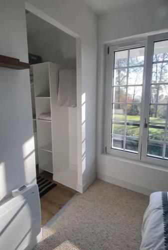 Cette chambre blanche dispose d'une fenêtre et d'un placard blanc. dans l'établissement Magnifique duplex avec jardin, à Rivière-Saas-et-Gourby