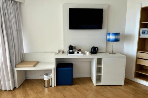 a white desk with a television on a wall at Cabot Pollensa Park Spa in Port de Pollensa