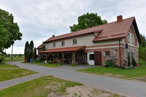 a large brick house with a road in front of it at Agropensjonat Stręgielek in Stręgielek