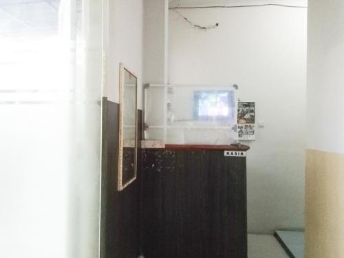 een magnetron bovenop een koelkast in een kamer bij RedDoorz near RS Labuang Baji in Balangberu