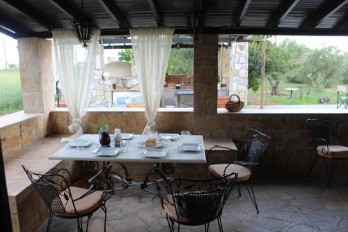 einen weißen Tisch und Stühle in einem Zimmer mit Fenster in der Unterkunft Country House in Paralia Dionisiou