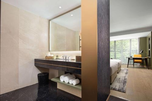 bagno con lavandino e specchio di Wyndham Taizhou West a Taizhou