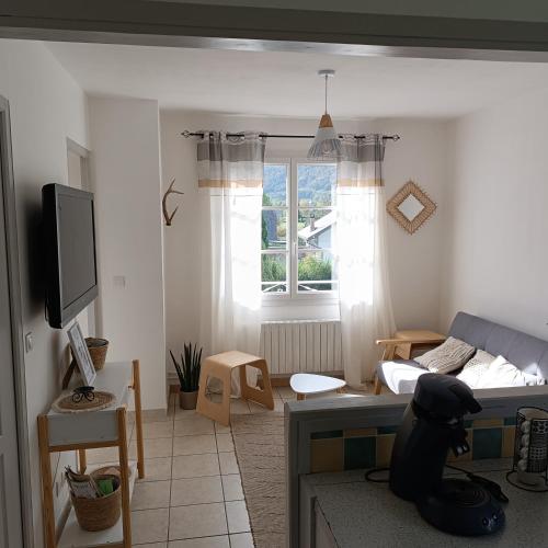 a living room with a bed and a television at Villa Bellevue in Montauban-de-Luchon