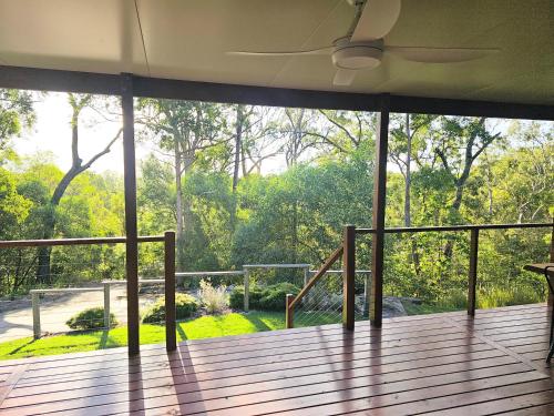 an empty porch with a large glass window on a deck at Little Mountain Retreat in Caloundra