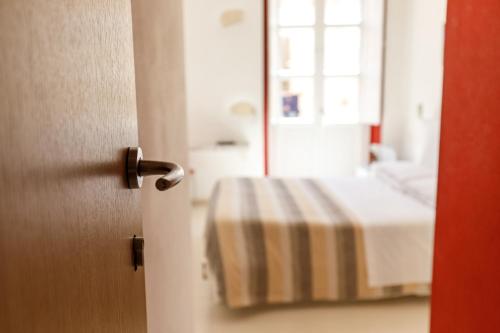 Habitación con cama y puerta con espejo. en Onlyrooms II - Real Old Town, en Cagliari