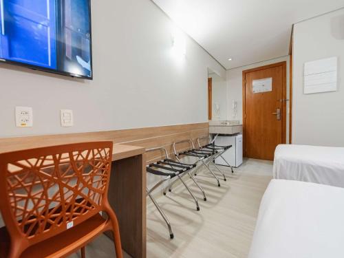 a room with chairs and a table and a bed at ibis Styles Goiânia Shopping Estação in Goiânia