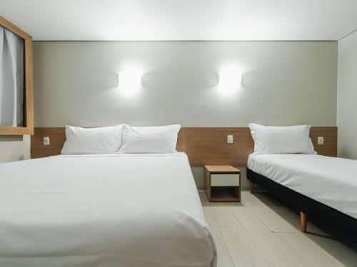 a hotel room with two beds and a window at ibis Styles Goiânia Shopping Estação in Goiânia