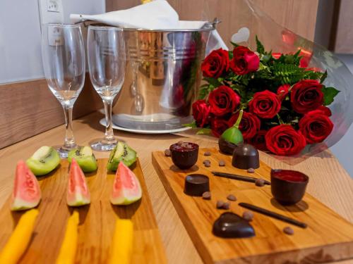 a table with two wine glasses and a bouquet of roses at ibis Styles Goiânia Shopping Estação in Goiânia