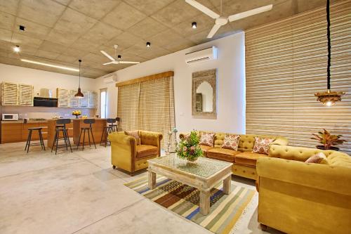 una sala de estar con un sofá y una mesa en Manna Villa, en Mahabalipuram