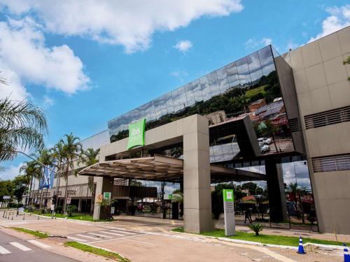 a building with a green sign on the side of it at ibis Styles Goiânia Shopping Estação in Goiânia