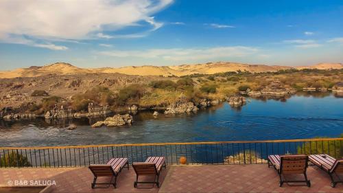 a group of benches sitting on a balcony overlooking a river at B&B Saluga Sehel Island Nubian House in Aswan