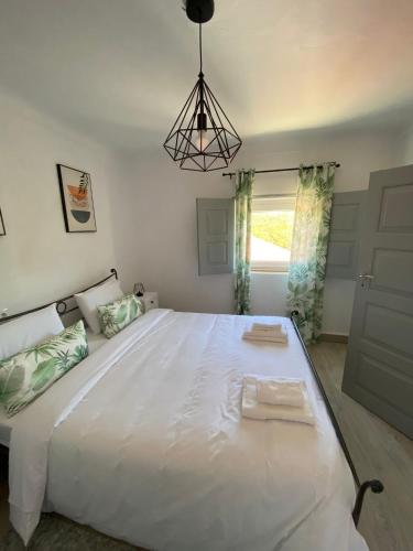 a large white bed in a room with a window at Casa do Balcão in Meda