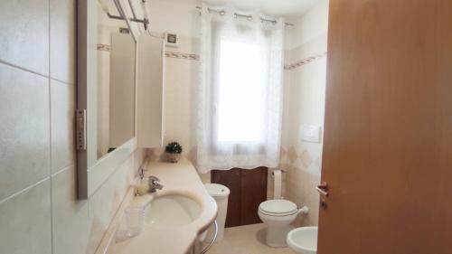 La salle de bains est pourvue d'un lavabo, de toilettes et d'une fenêtre. dans l'établissement Donatellaguesthouse, à Piove di Sacco